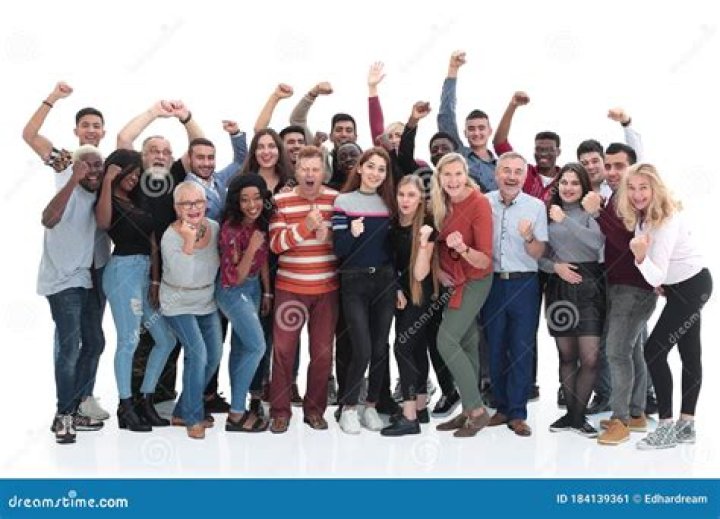 a group of people standing next to each other in front of a cross