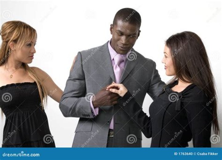 two women and a man posing for a photo on the red carpet at an awards event